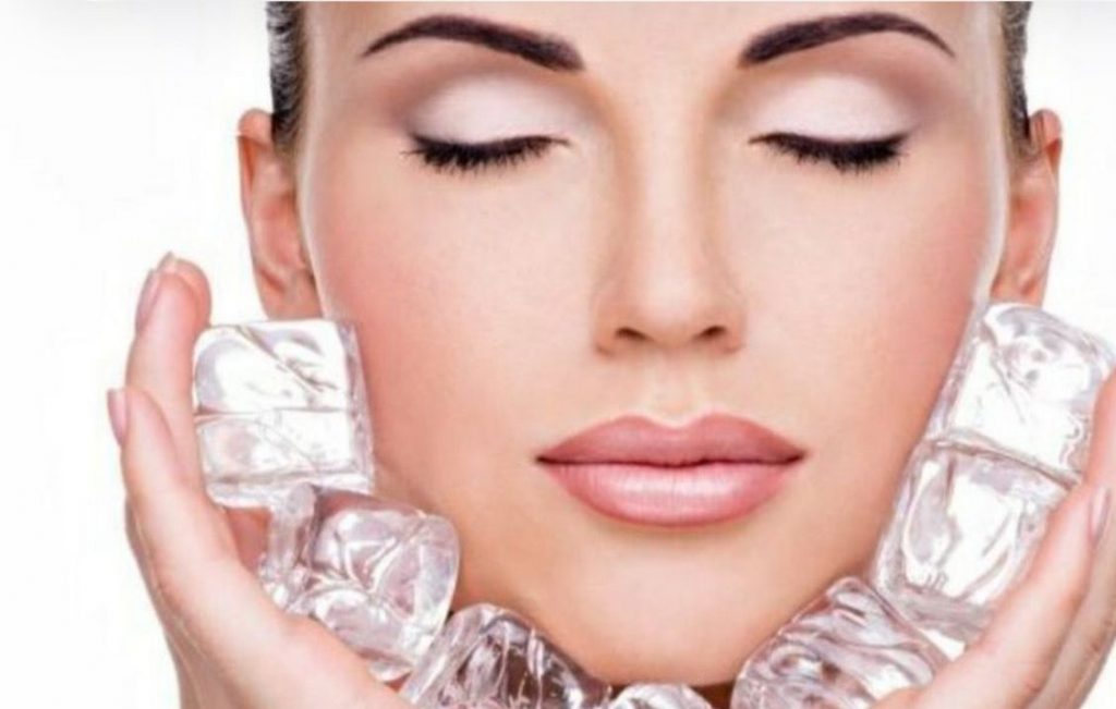 Mujer con hielo en el rostro, cuidando su piel.