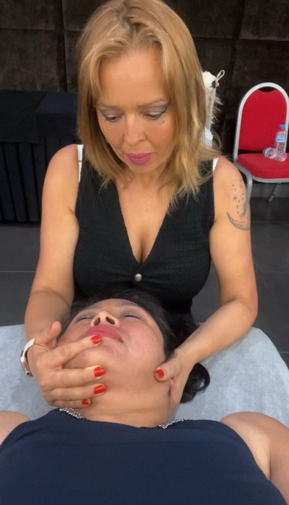 Masaje facial a mujer en un evento.